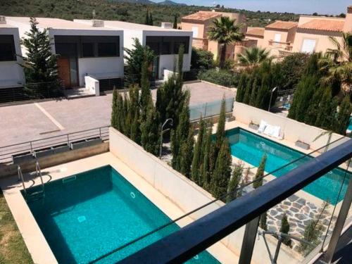 a view of a swimming pool from the balcony of a house at Luxus Chalet Casas blancas in Cala Mendia