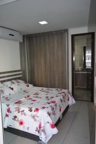 a bedroom with a bed with a floral bedspread at Grupo Vip Beach Class Fortaleza in Fortaleza