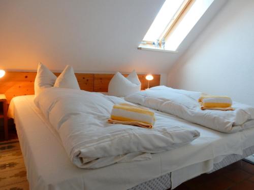 プレローにあるGästehaus Whg 9のベッドルーム1室(白いベッド2台、枕付)、窓が備わります。