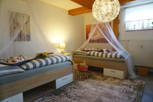 1 dormitorio con 2 camas y lámpara de araña en Ferienwohnung Schott en Marktredwitz