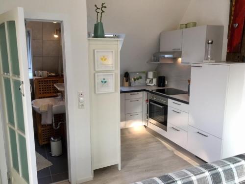 a kitchen with a white refrigerator and a sink at Ferienhaus an der Buche - 72952 in Neue Tiefe Fehmarn