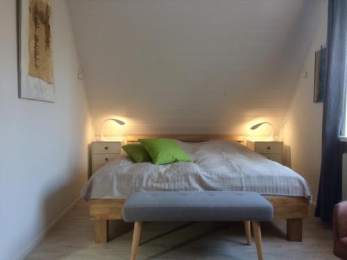 ein Schlafzimmer mit einem Bett mit einem grünen Kissen und zwei Lichtern in der Unterkunft Ferienhaus an der Buche - 72952 in Neue Tiefe Fehmarn