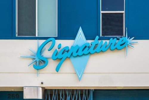a sign on the side of a building at Signature Inn North Houston District in Houston