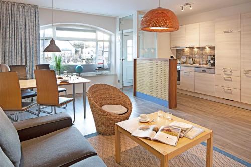 a living room with a table and a kitchen at Pure Wonne Mandoe in List