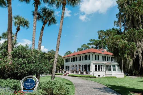 a white house with palm trees in front of it at Jekyll Island Club Resort in Jekyll Island