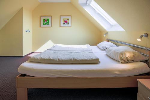 a bed in a room with an attic at Ferienhof Büdlfarm - Scheune in Sahrensdorf