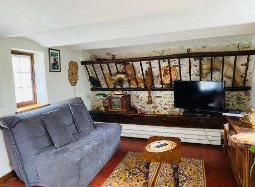 - un salon avec un canapé et une télévision dans l'établissement LES GITES DU JARIEL, à Jouy-sur-Morin