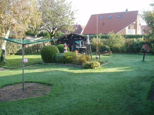 a yard with a swing set and a playground at Ferienhaus Astrid in Osteel