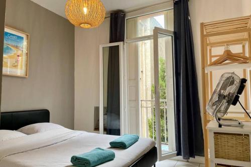 um quarto com uma cama e uma grande janela em Appartements Rue des Jardins em Perpignan