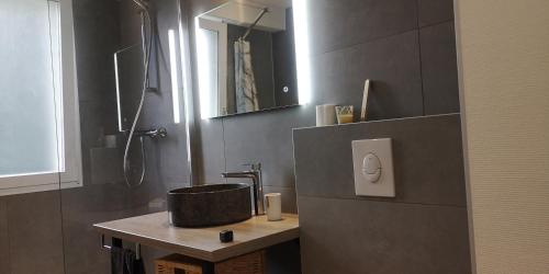 La salle de bains est pourvue d'un lavabo et d'une douche. dans l'établissement Moderne et paisible studio avec balcon, à Saint-Avold