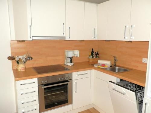a kitchen with white cabinets and a sink at Waldow - Ulmenhof 5 in Nieblum