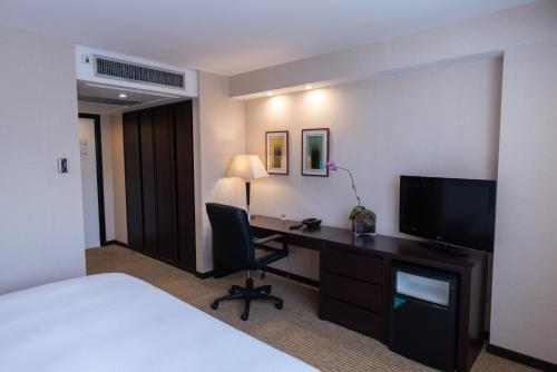a hotel room with a desk and a bed and a television at Eurobuilding Hotel & Suites Caracas in Caracas