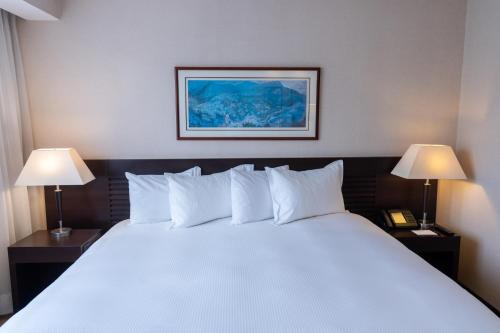 a bedroom with a large white bed with two lamps at Eurobuilding Hotel & Suites Caracas in Caracas