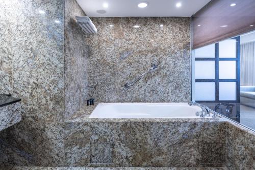 a large bathroom with a tub and a window at Eurobuilding Hotel & Suites Caracas in Caracas
