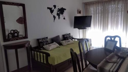 1 dormitorio con cama, mesa y TV en El departamento de la abuela en Mar del Plata