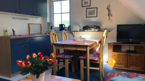 eine Küche mit einem kleinen Tisch und einem TV in der Unterkunft -"Große Koje" Fewo im OG - Fischländer Weg 53A in Dierhagen