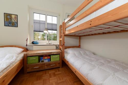 SüdstrandにあるHaus Falsterのベッドルーム1室(二段ベッド2台、窓付)が備わります。