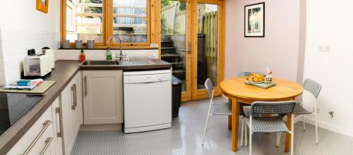 a kitchen with a wooden table and a small table with chairs at Bwthyn Gweilch in Machynlleth