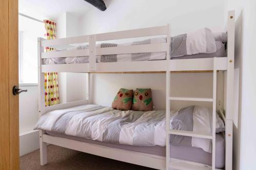 - un lit superposé blanc avec des oreillers dans l'établissement Bwthyn Gweilch, à Machynlleth