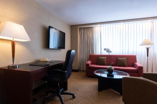 a hotel room with a desk and a couch at Eurobuilding Hotel & Suites Caracas in Caracas