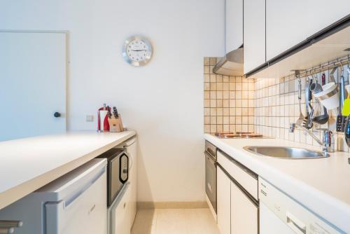 a kitchen with a sink and a counter top at Refurbished comfortable app 1min from the sea in Koksijde