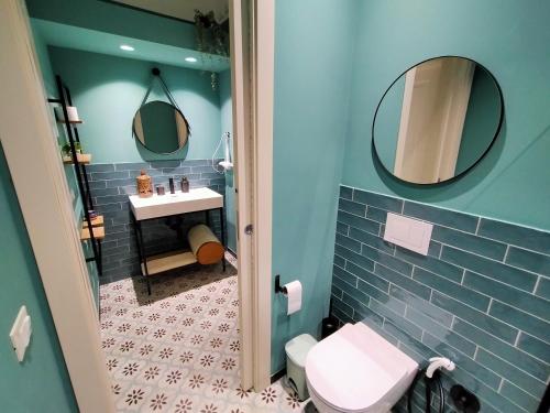 La salle de bains est pourvue de toilettes, d'un lavabo et de miroirs. dans l'établissement Sonnino Suite jacuzzi apartment, à Bari