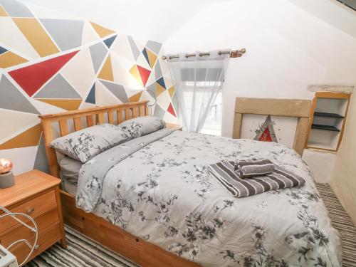 - une chambre avec un lit et un mur géométrique dans l'établissement Winslade, à Bradwell
