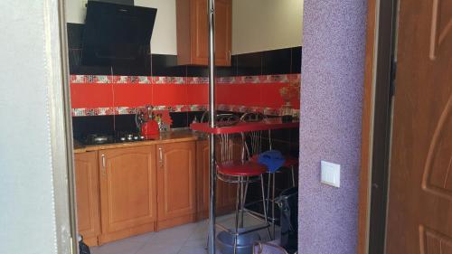 uma cozinha com paredes vermelhas e um banco de bar vermelho em VOLBIL em Lviv