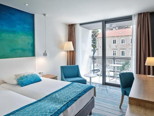 a hotel room with a bed and a large window at Maistra Select Mlini Hotel in Mlini