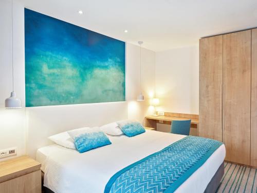a bedroom with a bed and a painting on the wall at Maistra Select Mlini Hotel in Mlini