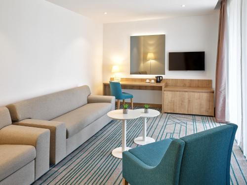 a living room with a couch and a table and chairs at Maistra Select Mlini Hotel in Mlini