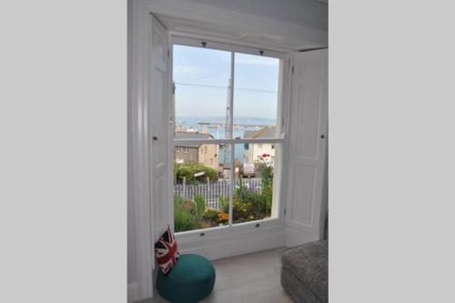 a room with a window with a view of a city at Luxury dog friendly home in Brixham harbour with sea views and free parking in Brixham