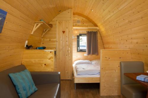 a small room with a bed in a wooden cabin at Kleine Nordseewelle ohne Hund - a16664 in Norden