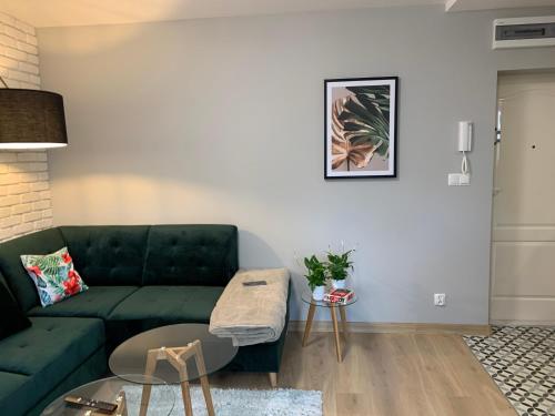a living room with a green couch and a table at Apartment Nadia in Ełk