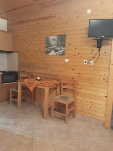 a kitchen with a table and chairs and a television at To Konaki in Kato Loutraki