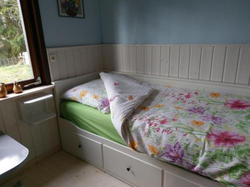 Dormitorio pequeño con cama y ventana en Ferienhaus Dornhecke, en Hatzfeld