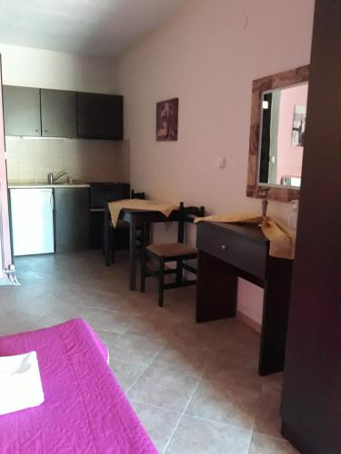 a room with a kitchen with a table and a desk at To Konaki in Kato Loutraki