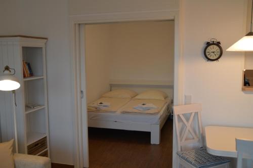 ein Schlafzimmer mit einem Bett und einer Uhr an der Wand in der Unterkunft Halligblick Whg 11 in Wyk auf Föhr