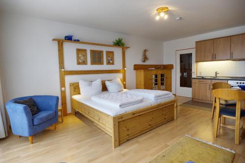 ツィングストにあるOstsee-Residenz Whg 12のベッドルーム1室(ベッド1台、青い椅子付)