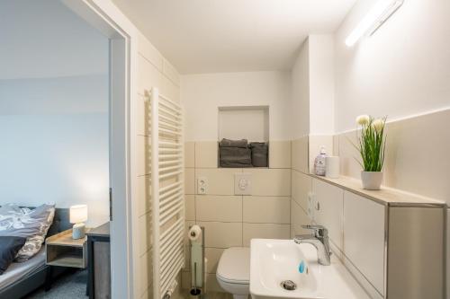 ein kleines Bad mit einem Waschbecken und einem WC in der Unterkunft Gästezimmer Teltow in Teltow