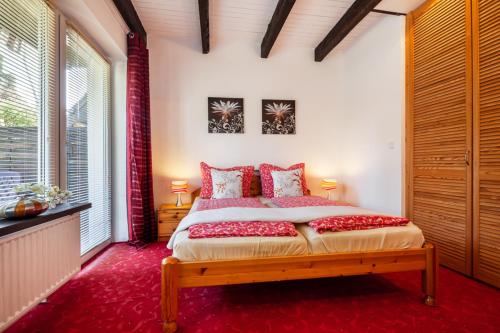 a bedroom with a large bed with red pillows at Haus Pia in Grömitz