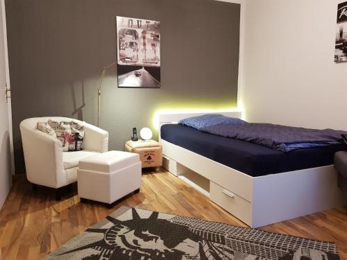 - une petite chambre avec un lit et une chaise dans l'établissement Blütenzauber Apartment No 1, à Mittelnkirchen