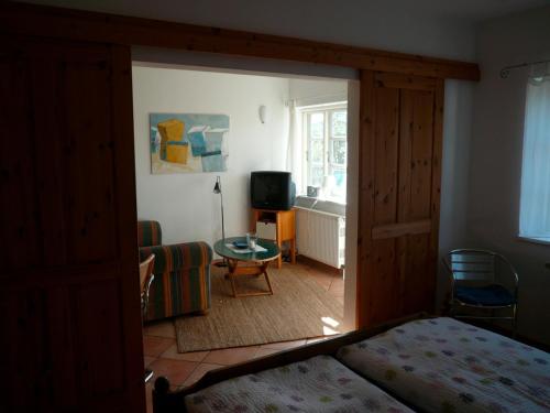 a bedroom with a bed and a living room with a tv at Landhaus-Marwede App 3 in Haffkrug