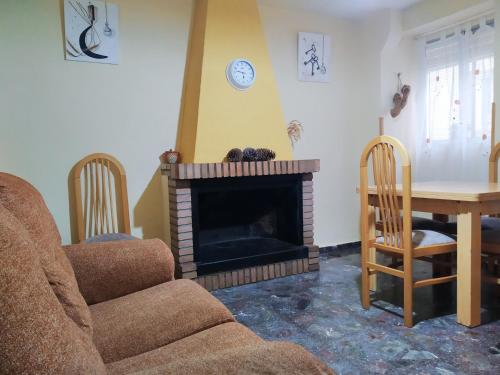 a living room with a fireplace and a table and chairs at CASA RURAL CELIA con Escape Room in Ayna