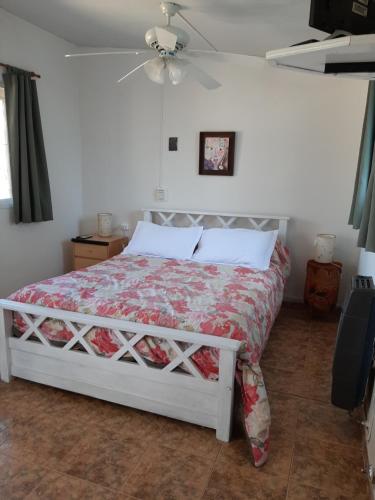 1 dormitorio con 1 cama con edredón rojo en Apart Cabaña La Unica en Capilla del Monte