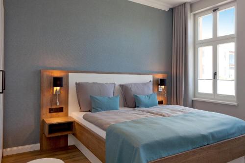 een slaapkamer met een bed met blauwe lakens en een raam bij Villa Seeblick "Balmer See" in Ahlbeck