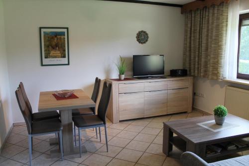 ein Wohnzimmer mit einem Tisch und einem TV in der Unterkunft Fewo Bayerischer Wald, mit Wlan in Arrach