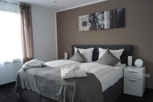 a bedroom with a large bed with white sheets at La Domus Superior Osnabrück Lotte in Lotte