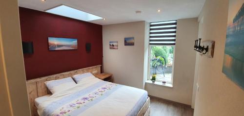 a bedroom with a large bed and a window at de Kempenvallei in Luyksgestel