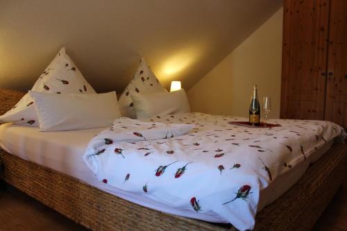 a bedroom with a white bed with a bottle of champagne at "Rosenkate 2" in Riepsdorf